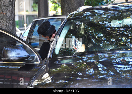 Laeticia Hallyday dressed causally and wearing a black hat as she gets into a car in Paris Paris, France - 23.09.11 Stock Photo