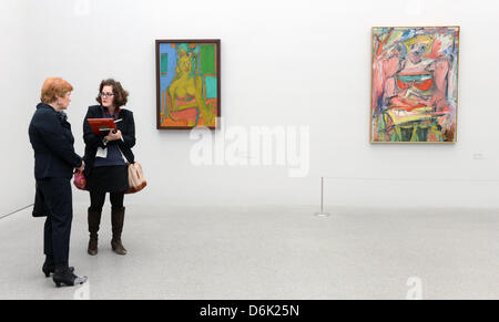 Curator Carla Schulz-Hoffmann (L) talks to a visitor in front of a set of paintings titled 'Women' and 'Women V' from 1952-53 and 1944 by Willem de Kooning in the exhibition 'Women' at the Pinakothek der Moderne arts venue in Munich, Germany, 29 March 2012. The art venues features an exhibition about feminity from the perspective of three 20th century painters on the occasion of th Stock Photo