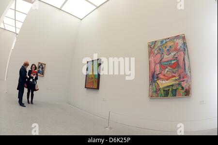 Curator Carla Schulz-Hoffmann (L) talks to a visitor in front of a set of paintings titled 'Women' and 'Women V' from 1952-53 and 1944 by Willem de Kooning in the exhibition 'Women' at the Pinakothek der Moderne arts venue in Munich, Germany, 29 March 2012. The art venues features an exhibition about feminity from the perspective of three 20th century painters on the occasion of th Stock Photo