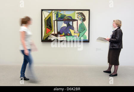 Visitors observe the painting 'Interior with a Girl Drawing' from 1935 by Pablo Picasso at the Pinakothek der Moderne in Munich, Germany, 29 March 2012. On the occasion of its 10th anniversary the Pinakothek der Moderne presents a view on femininity from the perspective of three 20th century painters. The exhibition titled 'Women' opens on 29 March 2012 and runs till 15 July 2012.  Stock Photo