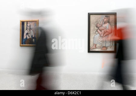 Visitors walk past the paintings 'Quappi in Rosa' (1932-34, L) by Max Beckmann and 'Maternite' from 1921 by Pablo Picasso at the Pinakothek der Moderne in Munich, Germany, 29 March 2012. On the occasion of its 10th anniversary the Pinakothek der Moderne presents a view on femininity from the perspective of three 20th century painters. The exhibition titled 'Women' opens on 29 March Stock Photo