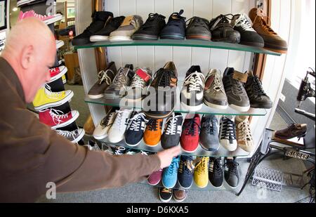 Shoemaker Georg Wessels places oversized men's shoes on a shelf in his shop in Vreden, Germany, 15 April 2013. Wessels manufactures shoes for people with large shoe sizes all around the world. Photo: Friso Gentsch Stock Photo