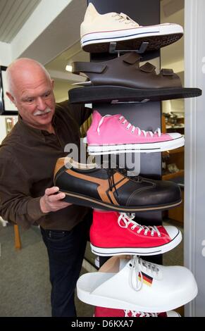 Shoemaker Georg Wessels places oversized men's shoes on a shelf in his shop in Vreden, Germany, 15 April 2013. Wessels manufactures shoes for people with large shoe sizes all around the world. Photo: Friso Gentsch Stock Photo
