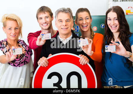 Driving school - driving instructor and student drivers look at a tempo thirty Road sign, in the background are traffic signs Stock Photo