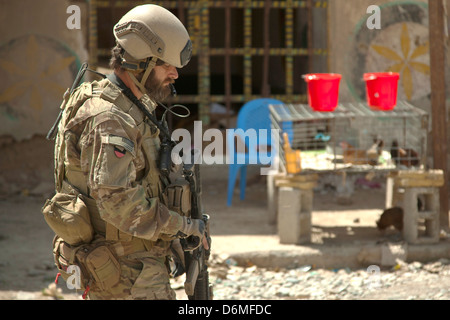 A US Special Forces soldier keeps watch during a patrol with Afghan National Army Special Forces escorting a district governor April 14, 2013 in Helmand province, Afghanistan. Stock Photo