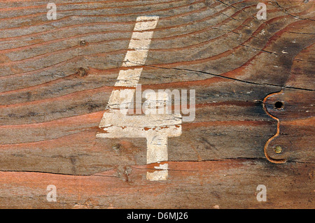 Number four faded stencil on old wood board grunge background. Stock Photo