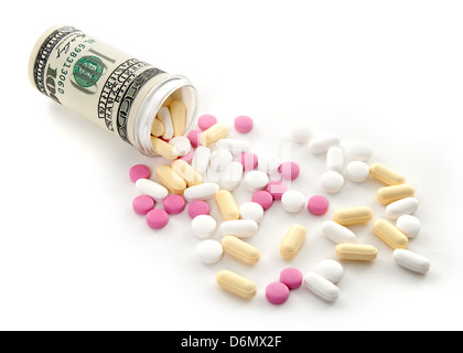 Colorful pills spilled from a bottle made of money, on white background. Stock Photo