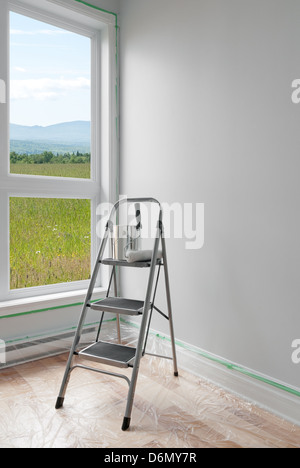 Renovations. Ladder and a can of paint in a room with beautiful view. Stock Photo