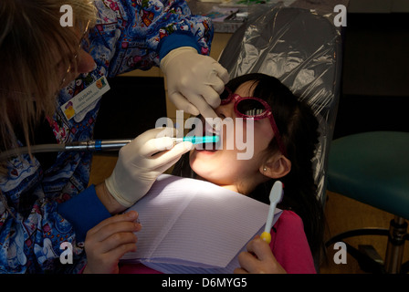 Dental assistant polishing young girl's teeth. Stock Photo