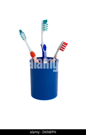 Three toothbrushes in the glass isolated on white Stock Photo