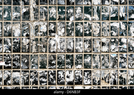 Dirty wall of Tiles covered with dirty pieces of paper Stock Photo
