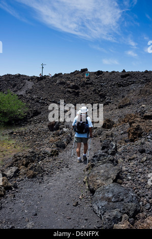 Walkers crossing the Chinyero lava field in the foothills of Mount Teide on Tenerife, Canary Islands, Spain. Stock Photo
