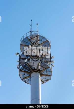 Communication mast for various antennae and dishes against blue sky Stock Photo