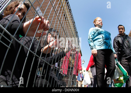 Activists enclosed in a cage are seen during a street performance Stock Photo