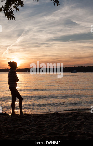 Berlin, Germany, a girl on the banks of the Havel river at sunset Stock Photo