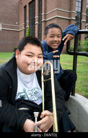 Black and Asian teen musicians from Ramsey school resting after performance. Grand Old Day Festival. St Paul Minnesota MN USA Stock Photo