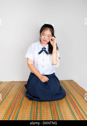 Crying Asian Thai Student in Sitting with Legs Folded Back to One Side Stock Photo