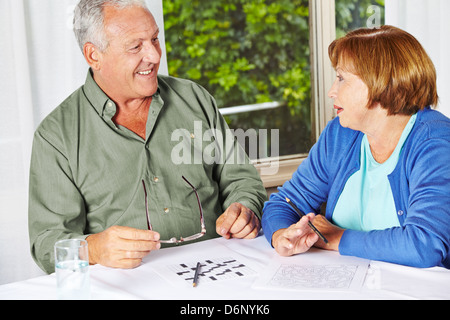 Two seniors doing memory training with riddles in a rest home Stock Photo