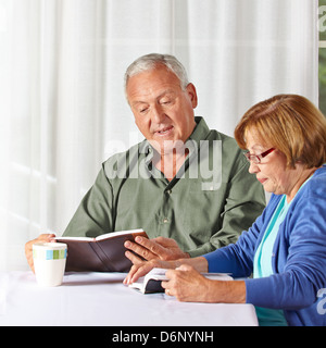 Senior couple reading books together in a rest home Stock Photo