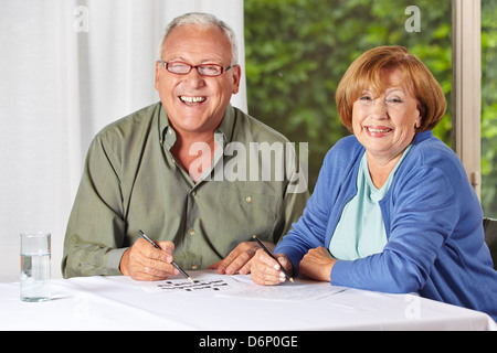 Two happy senior people solving riddles in a retirement home Stock Photo