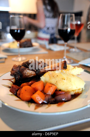 Lamb Shanks cooked slowly in red wine served with a garlic mashed potato and carrots