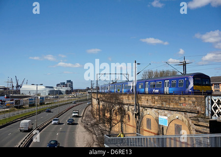 A Scotrail Class 170 Turbostar heading towards Partick Station beside Clydeside Expressway & Riverside Museum by River Clyde (L) Stock Photo
