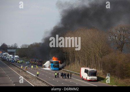 The former Rolling Stones tour bus ablaze on the M6 in Staffordshire. Scott Davids stock car racer has his car destroyed the fir Stock Photo