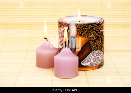 Three candles on bamboo background. Stock Photo