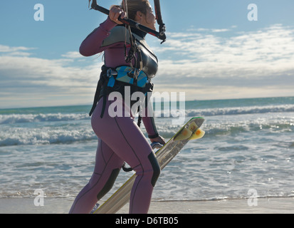 Kitesurfer walking along the beach. Tarifa, Costa de la Luz, Cadiz, Andalusia, Spain, Europe. Stock Photo