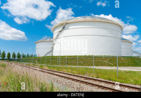 large white tanks for petrol and oil in the Amsterdam harbor Stock Photo