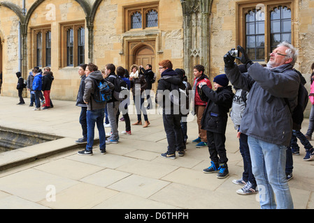 Schoolchildren and tourists taking photographs in Tom Quadrangle of Christ Church college, University of Oxford, Oxfordshire, England, UK, Britain Stock Photo