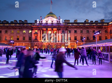 Skaters at Somerset House ice rink at twilight / dusk / night The Strand London England UK Stock Photo