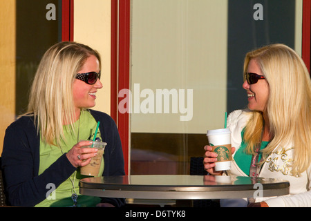 Two female friends having coffee at an outdoor cafe in Tampa, Florida, USA. MR Stock Photo