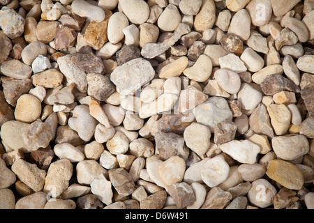 Small sea stones in a glass vessel. The idea of decorating the house with small  rocks in a jar on a wooden blurred background. Stock Photo