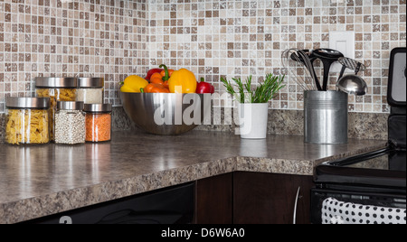 Food ingredients and green herbs on modern kitchen countertop. Stock Photo