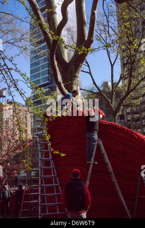 Workers install sections of 'Red, Yellow and Blue' by the artist Orly Genger in Madison Square Park in New York Stock Photo