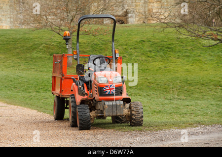 A union jack British flag on the front of a small red tractor lawnmower lawn mower Stock Photo