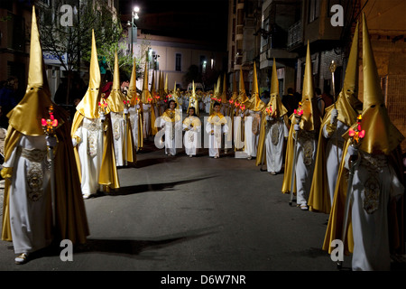 Nazarenos in a night time procession during Semana Santa (Holy Week) in Cartagena, Spain Stock Photo
