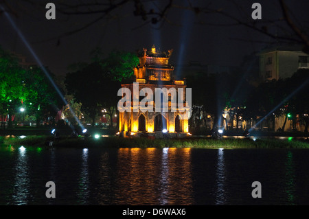 Horizontal view of Thap Rua, Tháp Rùa aka Turtle Tower in the middle of Hoan Kiem Lake in Hanoi lit up at night. Stock Photo