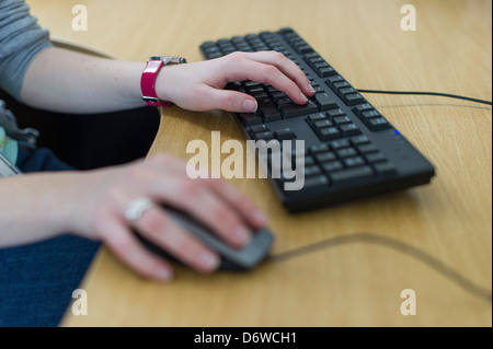 hands using a mouse and keyboard on a computer Stock Photo