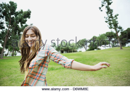 Cheerful young woman enjoying herself in park