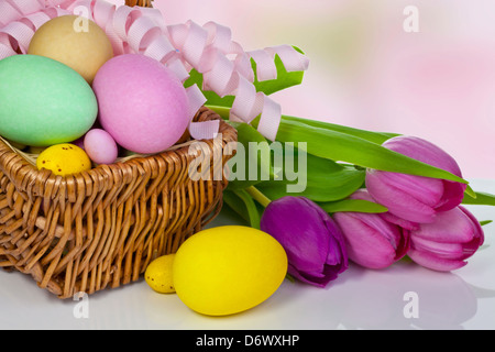 Large and small different colour Easter eggs in a basket. Stock Photo