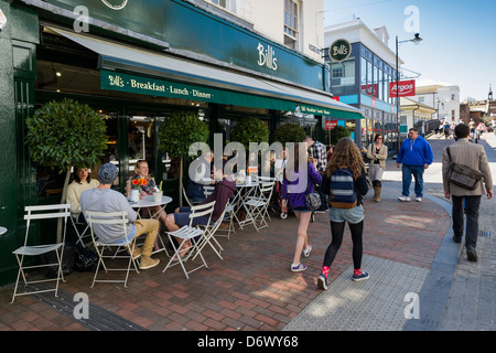 People sitting at tables outside Bills restaurant in Cliffe High Street in Lewes. Stock Photo