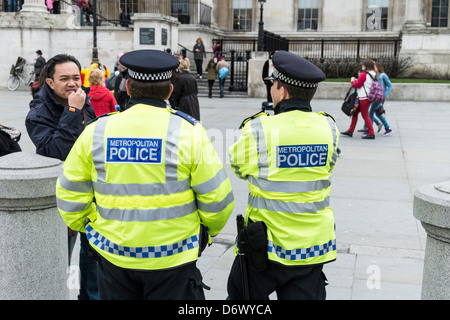 Two Metropolitan Police Officers talking to a tourist in London.