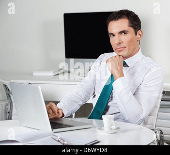 Pensive businessman working with laptop at his desk in the office Stock Photo