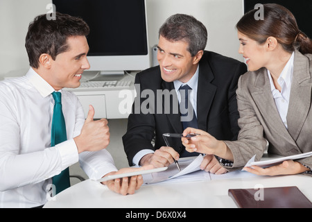 Happy manager in business meeting holding his thumb up Stock Photo