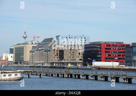 A view across the River Spree at the mediaspree buildings complex (from L) the Germany headquarter of Universal Music, the former granery which accommodates office lofts, the new four-star hotel of Spanish hotel chain NH and the newly constructing building with a red facade marking the Germany headquarter of  Coca-Cola Company in Berlin, Germany, 15 April 2013. Photo: Jens Kalaene Stock Photo