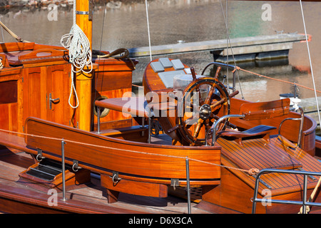 Captains steering wheel on wooden yacht. Stock Photo