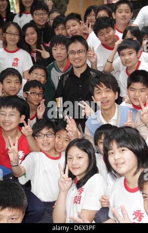 Japanese writer Hirotada Ototake and Chinese singer Michael Wong shared positive spirits with school kids in Taipei, Taiwan, China on Tuesday April 23, 2013. Stock Photo