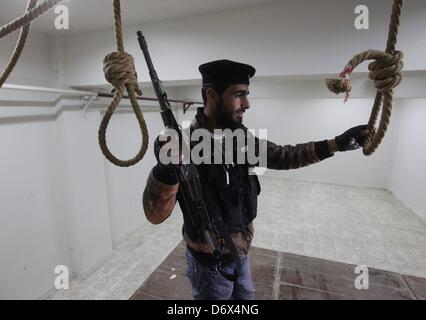 Darkoush, Syria. April 23, 2013. A Free Syrian Army soldier in a room where political prisoners were hanged  by Al-Assad forces inside the central prison on Darkoush, Syria. April 23, 2013. . The prison was bombarded by fights between Al-Assad forces and Fee Army fighters three months ago. Credit: Gallo Images / Alamy Live News Stock Photo